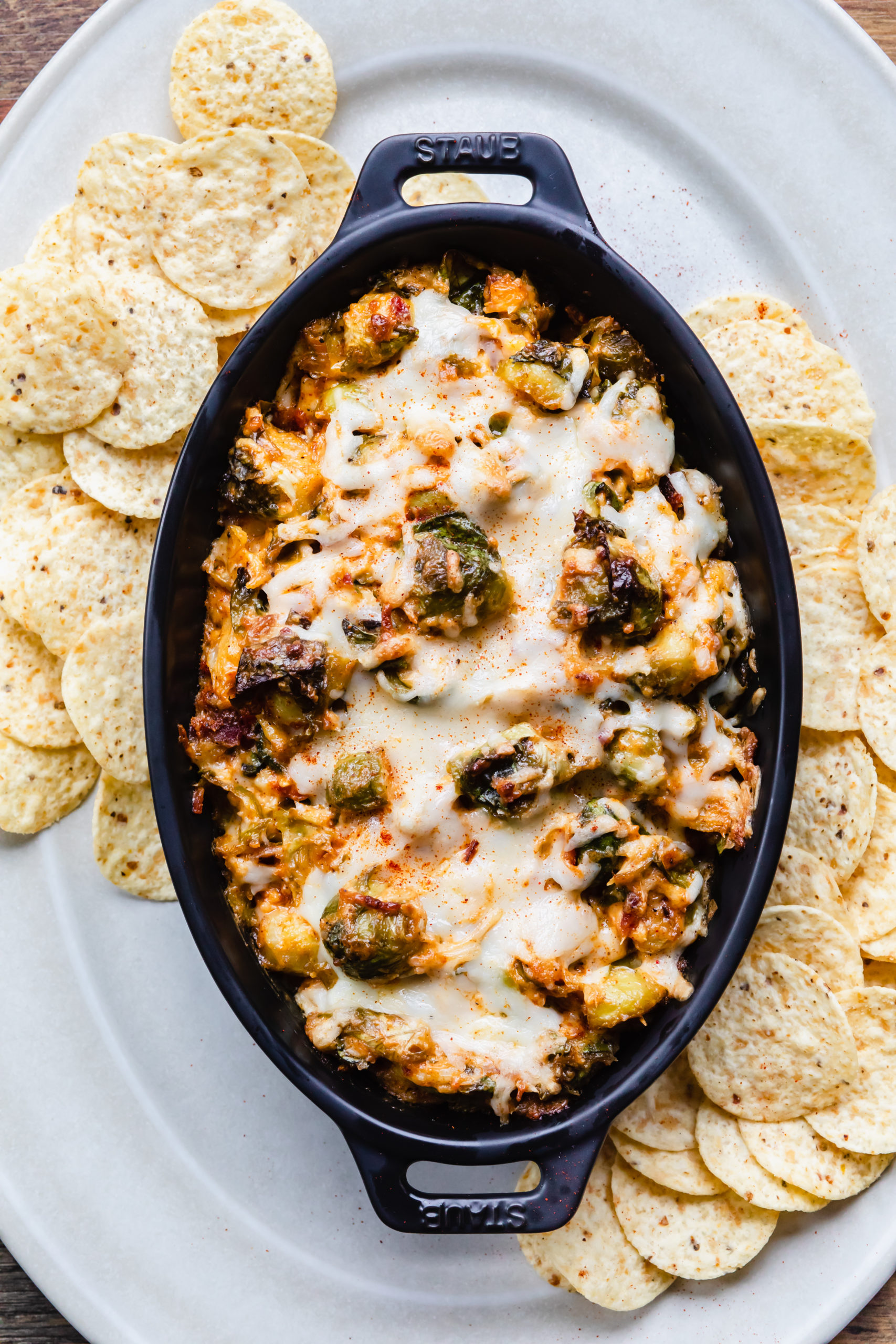 baked hot cheesy brussel sprout and bacon dip in black staub